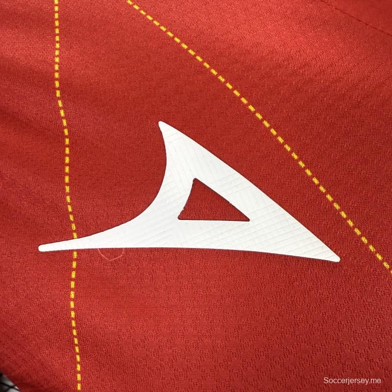 قميص اللاعب رقم 25/26 للنادي نيكاكسا (خارج أرضه) باللون الأحمر مع نقوش هندسية ذهبية على شكل صواعق