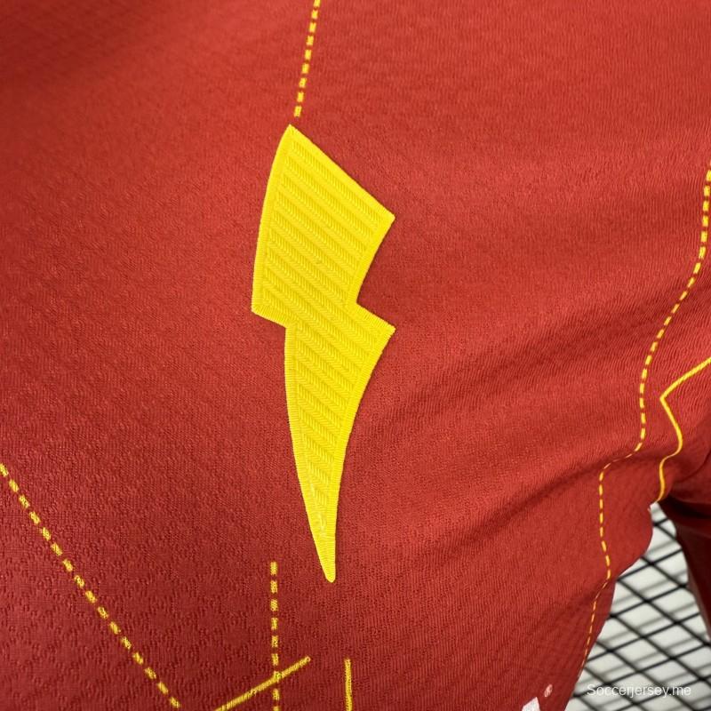 قميص اللاعب رقم 25/26 للنادي نيكاكسا (خارج أرضه) باللون الأحمر مع نقوش هندسية ذهبية على شكل صواعق