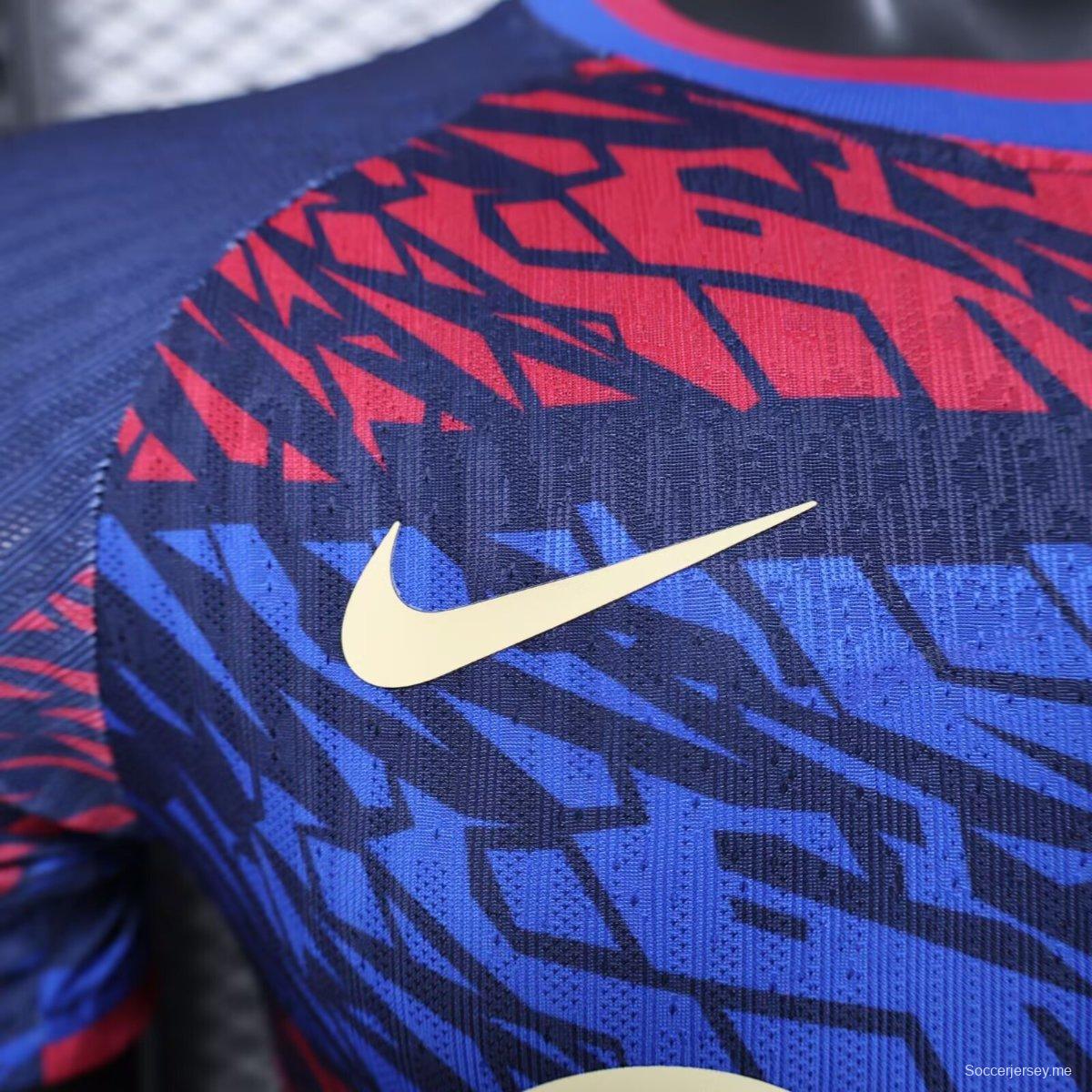 إصدار اللاعب 25/26 قميص نادي برشلونة باللون الأزرق الداكن مع نقشة تجريدية باللونين الأحمر والأزرق